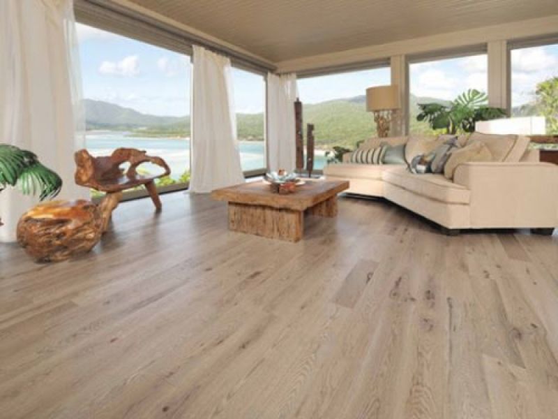 Amplio salón con ventanales y tarima de madera en tono claro