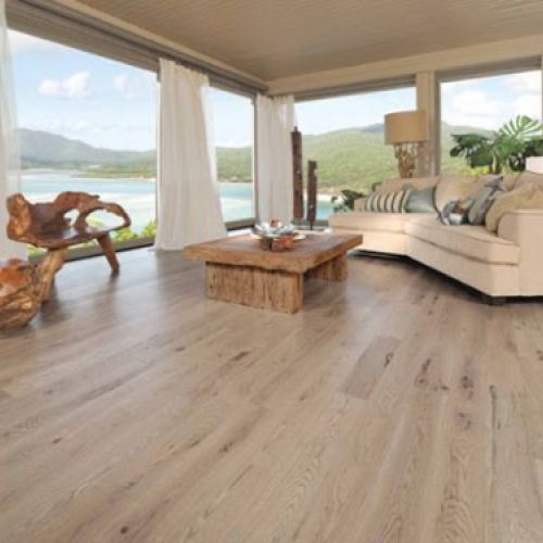 Amplio salón con ventanales y tarima de madera en tono claro